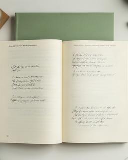 Saggio dalla copertina verde aperto su una scrivania con note scritte a mano